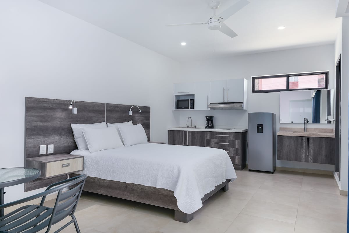 Une chambre à coucher moderne, avec un lit, une table de chevet et un petit bureau avec une chaise.