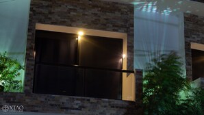 Fachada moderna de un edificio con un gran ventanal y pared de piedra.