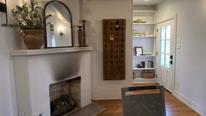 Una sala de estar con chimenea, un espejo y un revestimiento de madera.