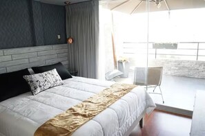 Un dormitorio con una cama grande, vista al balcón y diseño moderno.