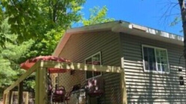 A mobile home with a fenced porch area. - Go out on an Adventure! Relax & Unwind at our cozy & quiet location.Pet Friendly (Munising)