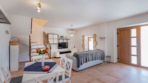 A modern living room with a dining area, a TV, and a bed. - Rückzugsort am Meer mit Pool, nur Wenige Minuten vom Strand Entfernt (Trget)