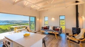 Un amplio salón con vistas al campo, una chimenea y una mesa de comedor.