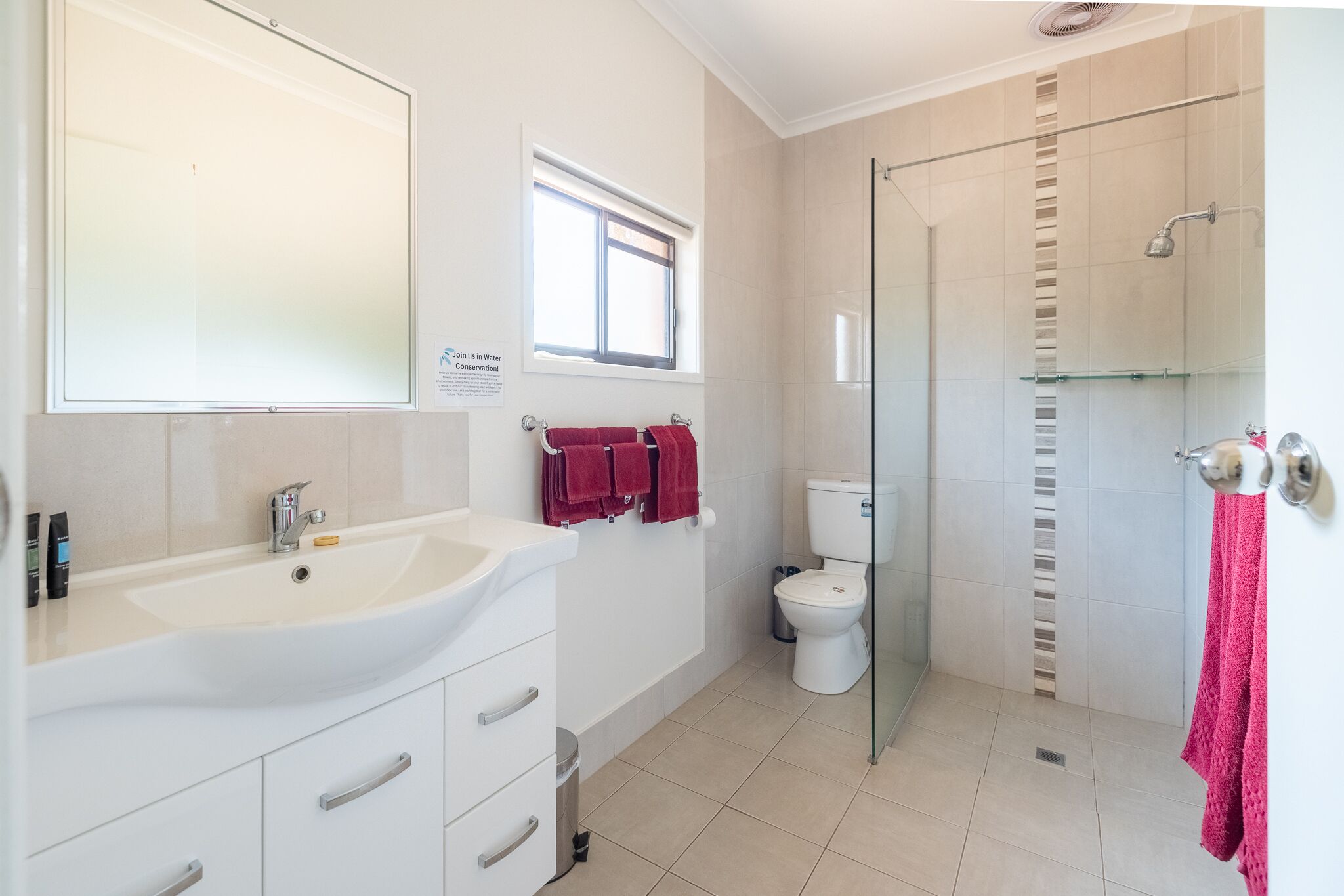 A modern bathroom with a large sink, a toilet, and a glass-enclosed shower.