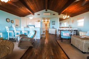 Cozy space with a central dining area, kitchen, and comfortable seating options.