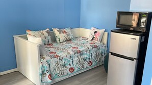 A room with a sofa bed, a microwave, and a refrigerator. - Spacious, comfortable rooms near beach & Newport (Middletown)