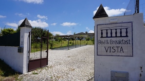 A gated entrance to a property named 'Bed & Breakfast Vista' with a cobblestone path leading to the gate.