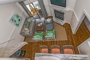 A modern living room with a sofa, chairs, a fireplace, and a dining area. - Updated condo with balcony view of the golf course! Community Pool (Bald Head Island)