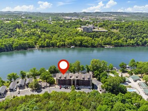 Eine Vogelperspektive auf ein Hotel mit einem großen Gebäude, umgeben von üppiger Vegetation und einem See.