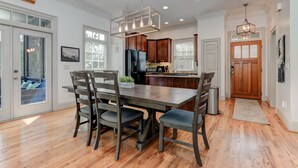 A modern kitchen with wooden cabinets, a central island, and pendant lighting.