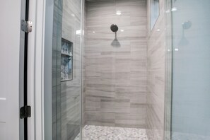 Regadera, secadora de cabello, toallas, papel de baño 