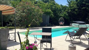 A poolside area with a table and chairs, a covered seating area, and a potted plant. - A peaceful haven with swimming pool, 20 minutes from Bordeaux and its vineyards. (TRESSES)