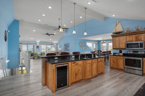 A modern kitchen with wooden cabinets, stainless steel appliances, and pendant lighting. - Atabey-Amazing Home! Private pool, 2 hot tubs, elevator, rec room, ocean views! (Corolla)