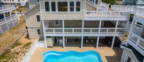 A multi-story building with a swimming pool and outdoor seating.