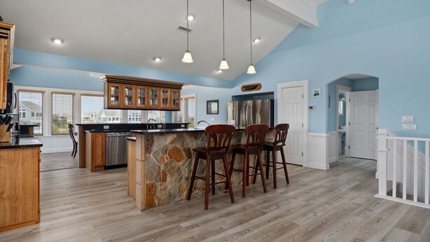 A spacious kitchen with a central island, wooden bar stools, and pendant lighting. - Atabey-Amazing Home! Private pool, 2 hot tubs, elevator, rec room, ocean views! (Corolla)