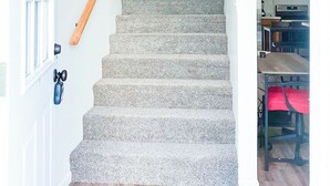 A staircase with carpeted steps leading to a landing. - Cozy 2BR, 1BA Getaway in Macomb, IL (Macomb)