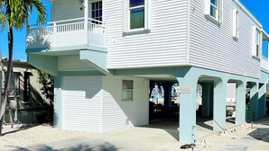 En tvåvåningsbyggnad med en balkong på övre våningen, ett garage och en överbyggd uppfart.