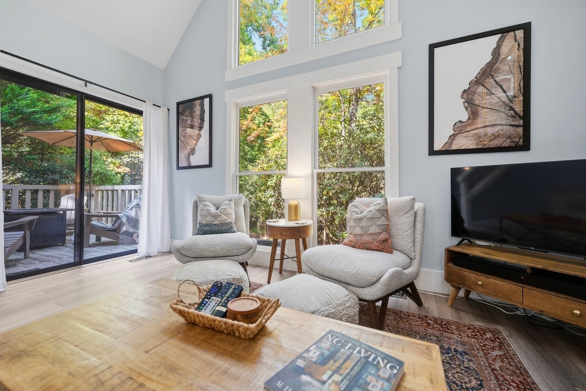 A spacious living room with a large window, a television, and a cozy seating area.