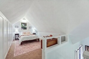 A bedroom with a bed, bedside tables, a window, and a built-in shelf. - Cozy Sapphire Retreat | Fireplace • Dog Friendly (Sapphire)