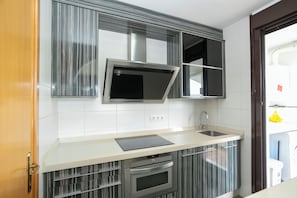 A modern kitchen with a built-in oven, a microwave, and a sink.