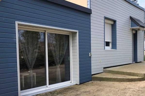 A house with a large sliding glass door and a small window.
