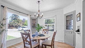 A dining area with a round table, four chairs, a chandelier, and a view of the outside. - Remodeled home with vintage charm. Centrally located near downtown Idaho Falls. (Idaho Falls)