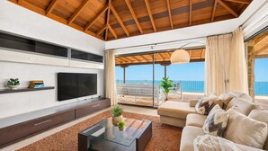 A modern living room with a TV, sofa, and a glass coffee table. - Villa in the mountain with views and pool (Adeje)