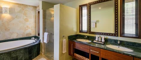 A bathroom with a bathtub, two sinks, a shower, and a large mirror.