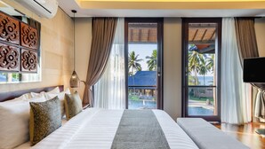 A hotel room with a large bed, a bench, a TV, and a view of palm trees and a pool. - Sundancer Residences & Villas Lombok (Sekotong Barat)