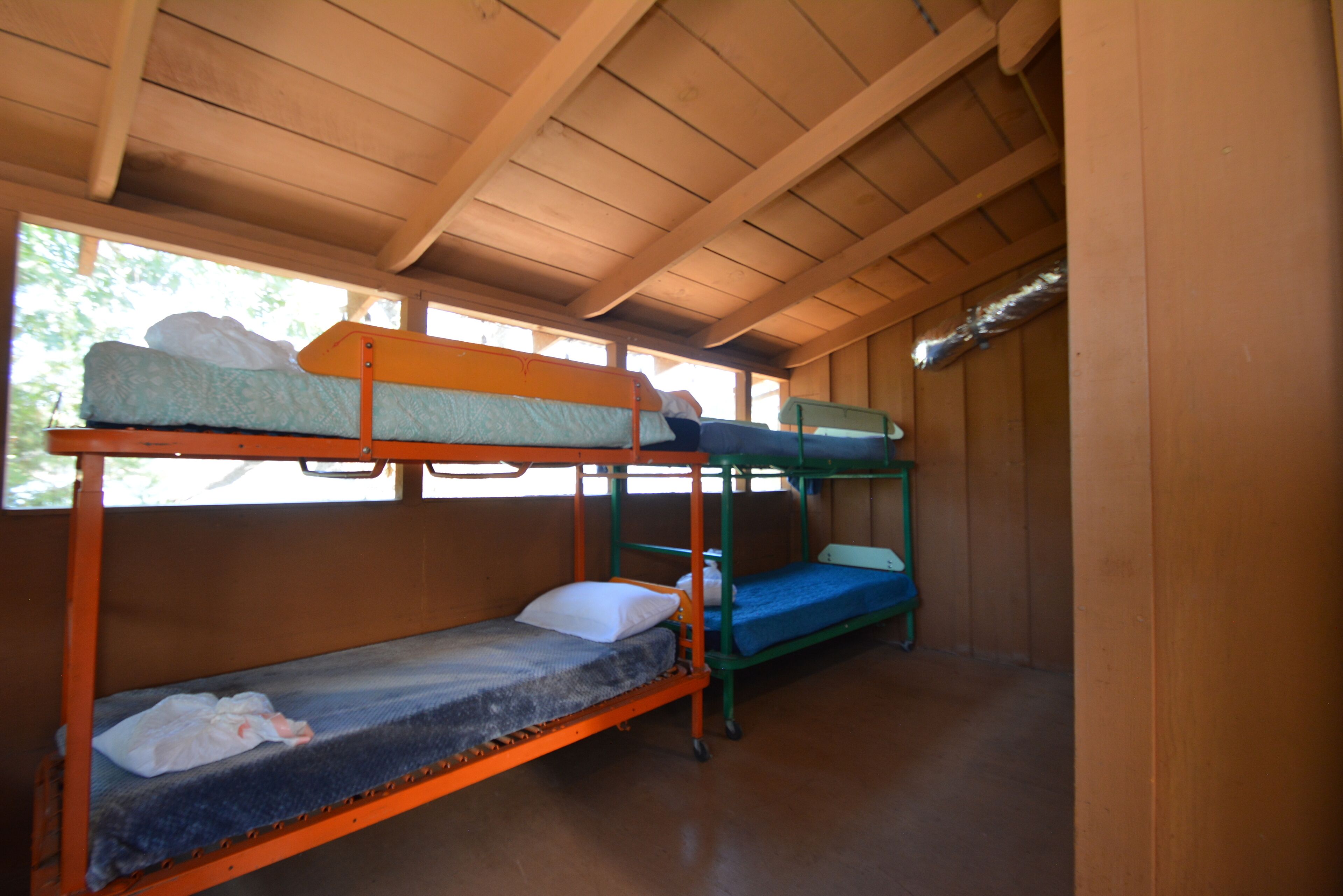 Des lits superposés dans une pièce en bois avec un plafond en pente.
