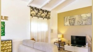 A modern living room with a sofa, TV, and decorative wall art. - Villa Kajoane, deluxe villa south of martinique close to beautiful beaches (Fort de France)