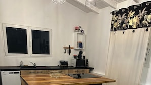 A modern kitchen with a central island, bar stools, and a microwave. - Villa Kajoane, deluxe villa south of martinique close to beautiful beaches (Fort de France)