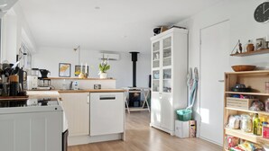 Una cocina moderna con armarios blancos, una isla central y una estufa empotrada.