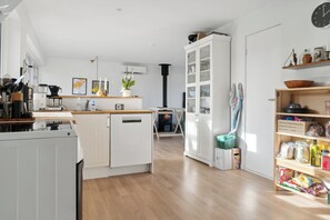 A modern kitchen with white cabinetry, a central island, and a built-in stove.