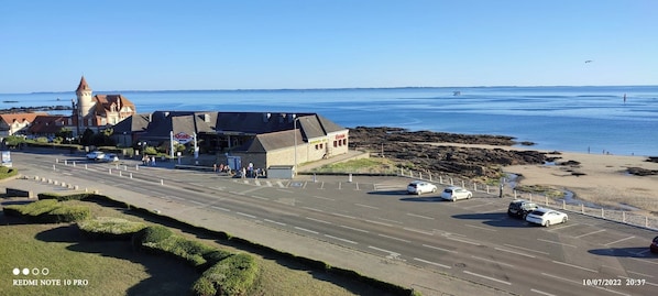 A coastal road with a casino and a beach.