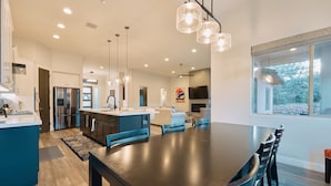 A modern kitchen with stainless steel appliances, a large island, and pendant lighting. - New Build in Heart of Sedona (Sedona)