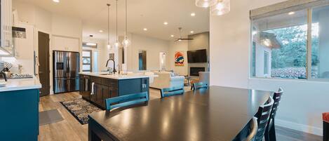 A modern kitchen with stainless steel appliances, a large island, and pendant lighting.