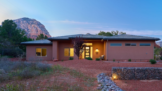 A two-story house with a stone retaining wall and a landscaped garden. - New Build in Heart of Sedona (Sedona)
