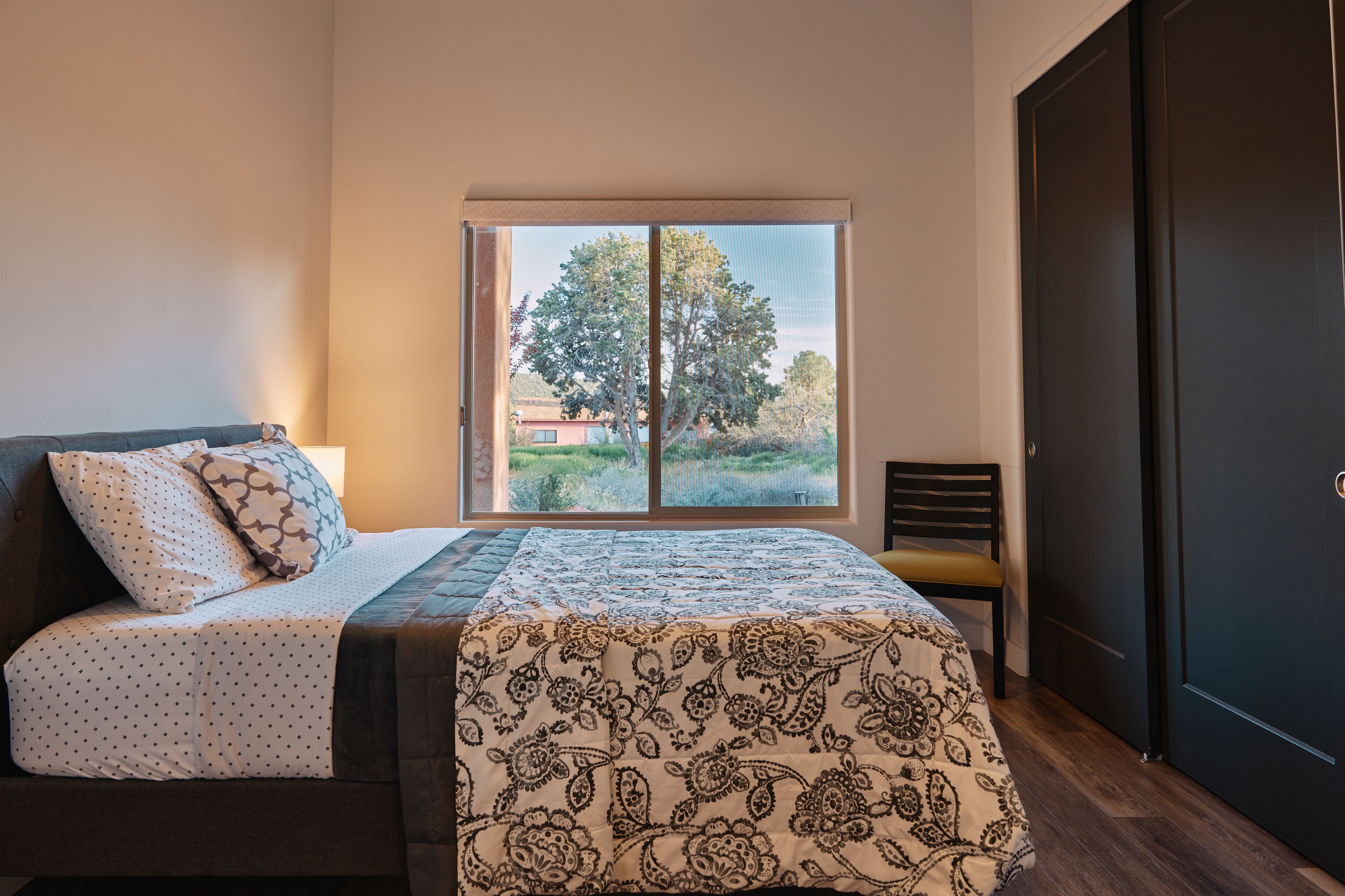 A bedroom with a bed, a window, and a door.