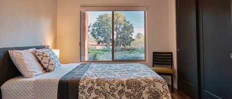 A bedroom with a bed, a window, and a door.