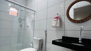 A modern bathroom with a toilet, sink, and shower. - Pousada e agência cledio turismo  (Barreirinhas)