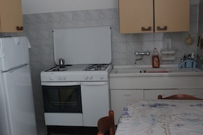 A kitchen with a stove, oven, sink, and cabinets.