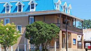 A two-story building with a blue roof and a balcony on the second floor.