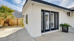 A modern house with a white exterior, black shutters, and a concrete patio. - Midterm Escape  Mountain Views & Desert Breezes (Palm Springs)