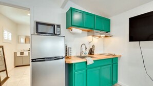 A modern kitchen with teal cabinets, a stainless steel refrigerator, a microwave, and a wooden countertop. - Midterm Escape  Mountain Views & Desert Breezes (Palm Springs)