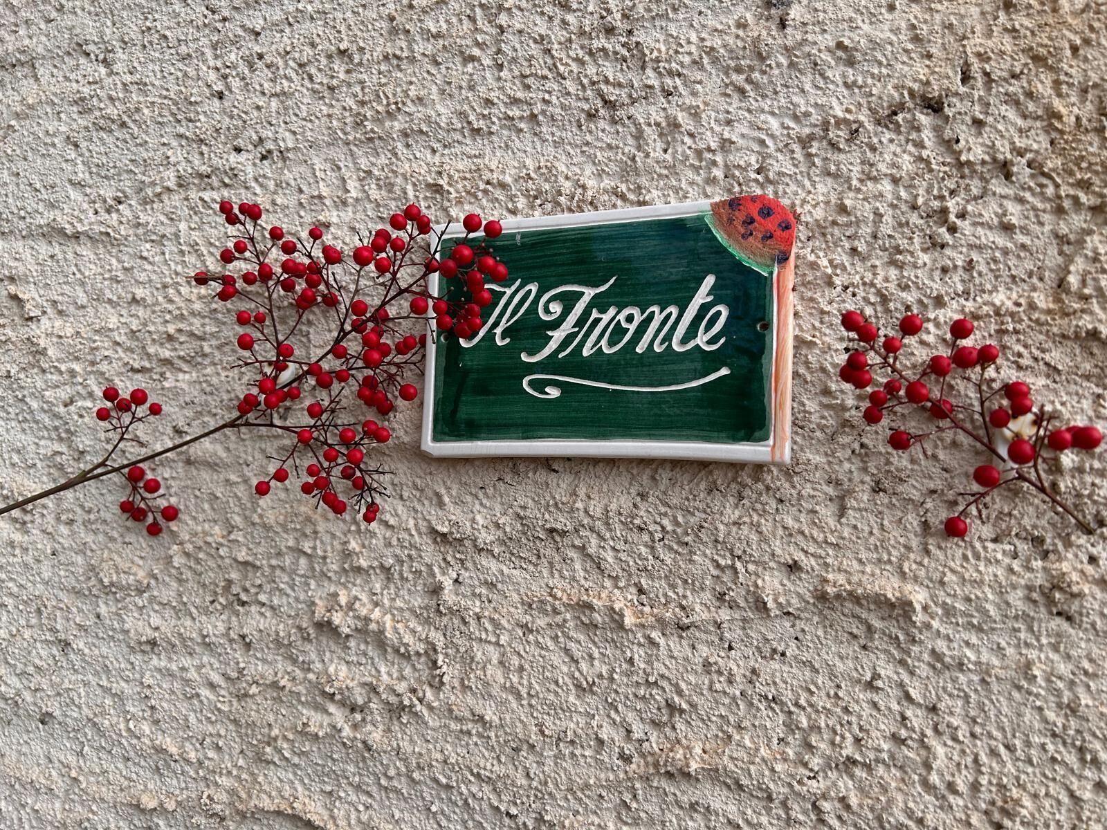 Un letrero con la palabra 'Il Fronte' sobre una pared texturizada.