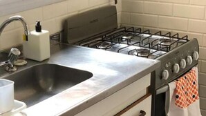 A kitchen with a stainless steel sink, a Bosch gas stove, and a white oven. - Cosy Studio in Recoleta, Buenos Aires. Walking distance from mayor attractions (CABA)