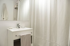 Une salle de bain avec un lavabo blanc, un miroir et un porte-serviettes.