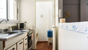 A compact kitchen with a sink, stove, and washing machine. - Cosy Studio in Recoleta, Buenos Aires. Walking distance from mayor attractions (CABA)
