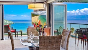 A balcony with wicker furniture, a glass table, and a view of the ocean. - Maui Resort Rentals: Honua Kai - 3 Total Bedrooms,  8th Floor "Penthouse" Ocean AND West Maui Mountain Views, Deluxe Corner Floor Plan! (Lahaina)